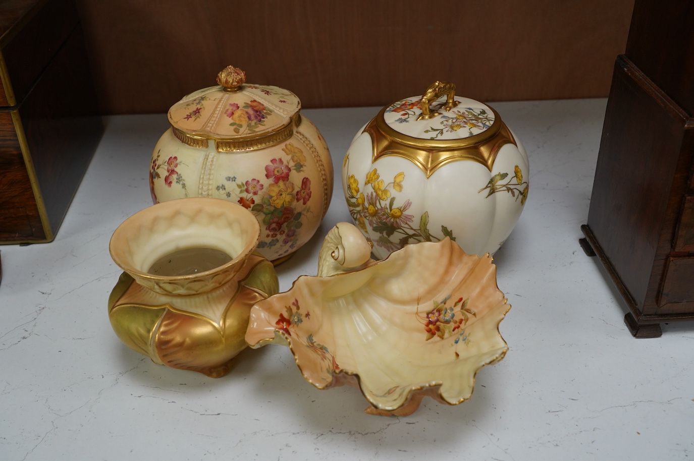 Two Worcester blush ivory biscuit jars and covers, numbers 1412 and 1796, a shell dish, number 971 and a vase, number 1877, tallest 17cm. Condition - mostly good, some wear to gilding